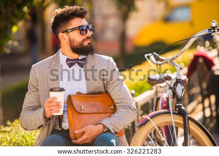 City bike. A young man with a beard, walk the city with bike