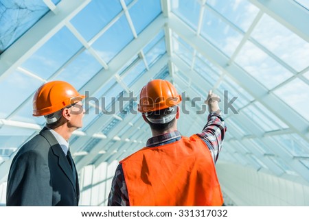 Portrait of a man construction builder in yellow helmet and vest the office center