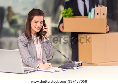 Young happy businessman and a business woman with boxes for moving into a new office