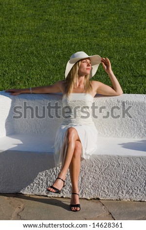high class woman sitting on a white bench