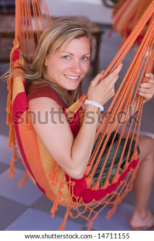 smiling blonde relaxing in a hammock chair