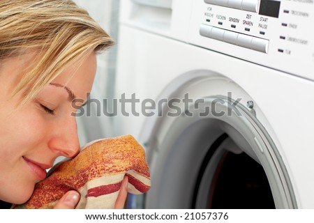 blonde female is smelling freshly washed laundry
