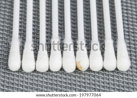 Cotton swab used for cleaning ear, with sulfur on gray background.