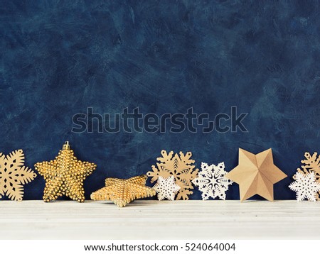 Christmas decoration on the blue vintage background. Paper snowflakes and gold stars. New year greeting card template. Holiday mock up. Scandinavian style.