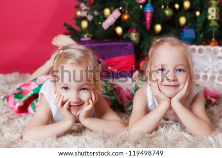 Twins lies in front of the xmas tree
