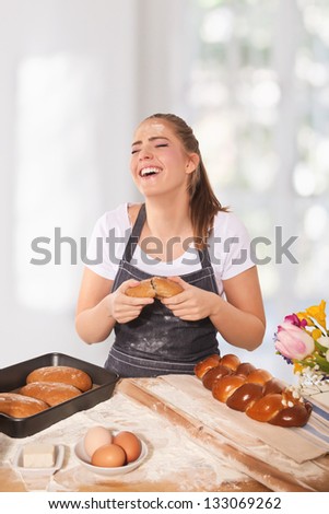Baking woman laughing during trying the fresh rye loaf