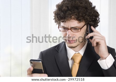 Troubled business man with two mobile phone