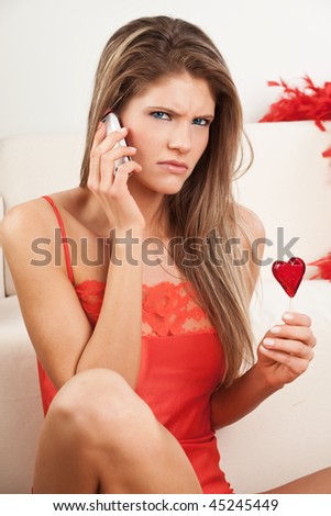 Young woman in red angry at the phone call