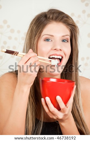 Beautiful woman eating  rice with sticks