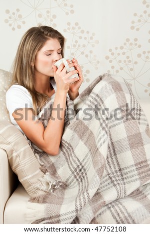 Young attractive  woman drinking tea in the bed