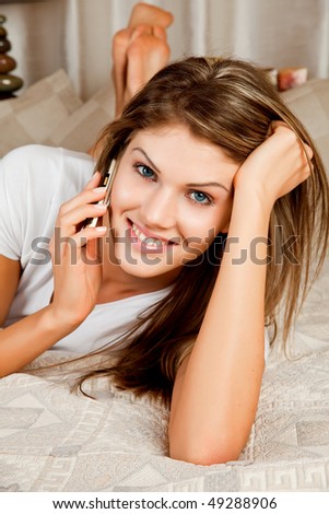 Young beauty woman couch in the bed and telephoning