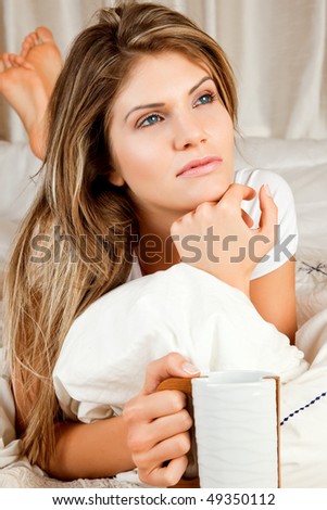 Young beauty woman couch in the bed with a mug