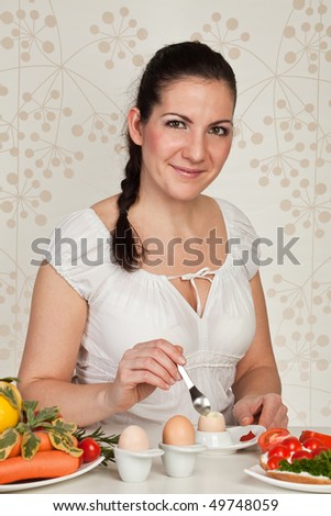 Young beauty woman eating eggs and salad
