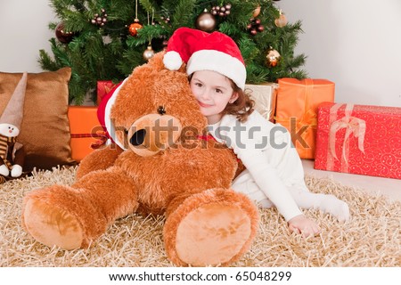 Little girl with a big teddy bear at Christmas