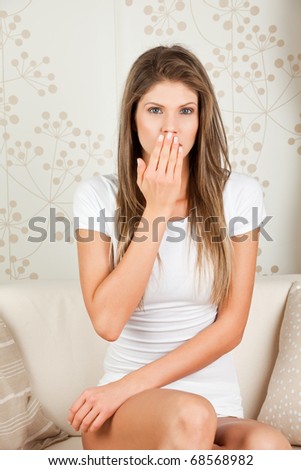 Young attractive  woman covering her mouth