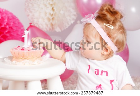 Cute baby tasting the birthday cake