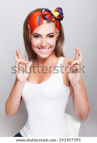 Beautiful happy woman crossing her fingers for good luck