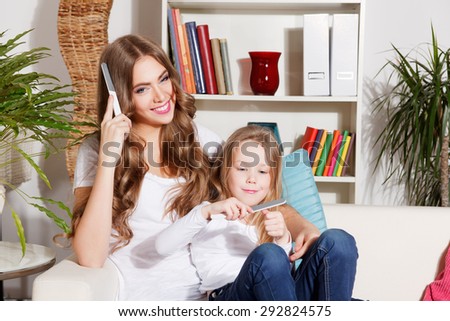 Happy mother and little daughter doing manicure