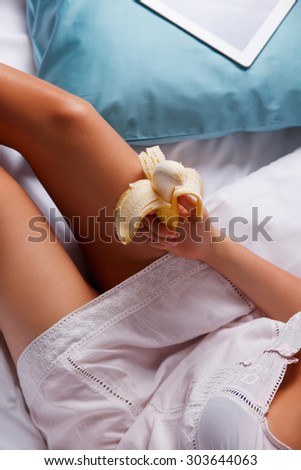 Woman eating a banana in the bed