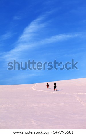 Two hikers on sunrise snow plateau. Turkey, Central Taurus Mountains, Aladaglar (Anti-Taurus) plateau Edigel (Yedi Goller)