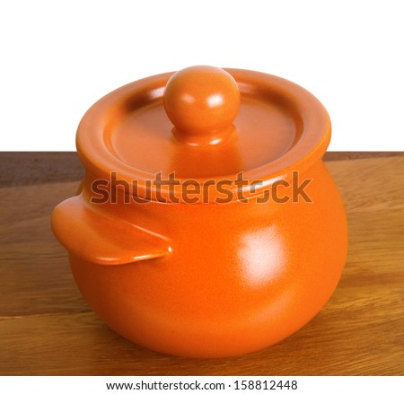 Kitchen ceramic pot on the wooden board. Isolated on white background.