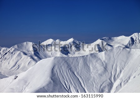 Off-piste slope with traces of skis and snowboards in nice day. Caucasus Mountains, Georgia, ski resort Gudauri.