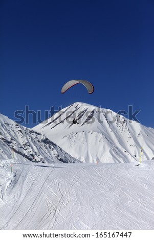 Skydiver in sunny snowy mountains. Caucasus Mountains. Georgia, ski resort Gudauri.