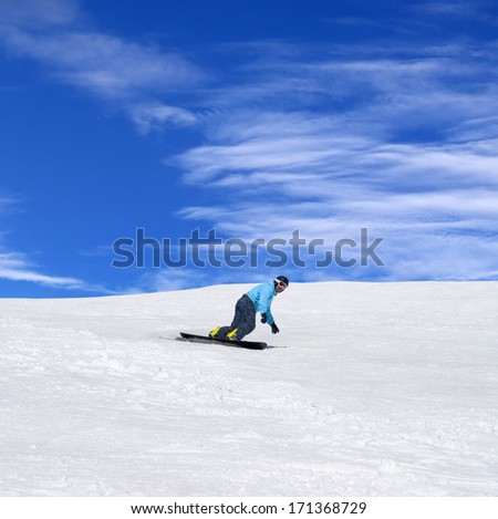 Snowboarder in winter mountains at nice sunny day