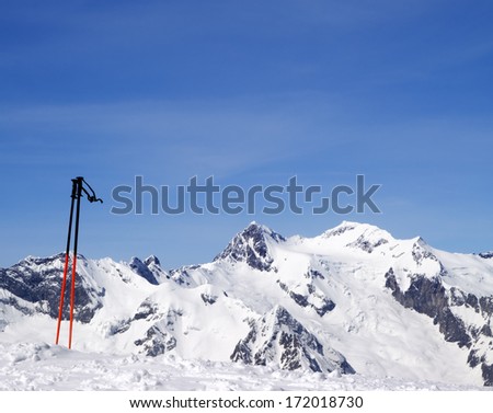 Ski poles and snowy mountains at nice day. Caucasus Mountains, Dombay.