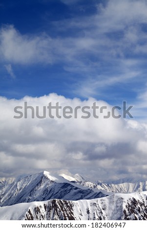 Winter snowy mountains and sky with clouds at nice day. Caucasus Mountains, Georgia, view from ski resort Gudauri.