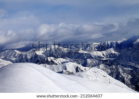 Off-piste snowy slope and mountains in cloud. Caucasus Mountains, Georgia, ski resort Gudauri.