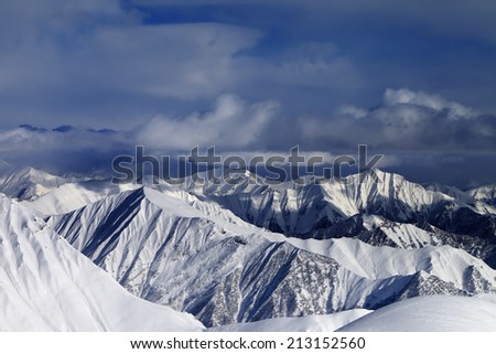 Sunlight snowy mountains and storm clouds. Caucasus Mountains, Georgia, ski resort Gudauri.