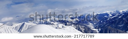 Panorama of off-piste snowy slope and cloudy mountains. Caucasus Mountains, Georgia, ski resort Gudauri.