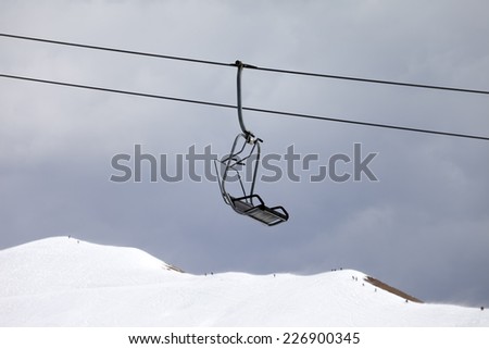 Chair lift and off-piste slope at gray day. Caucasus Mountains, Georgia, ski resort Gudauri.