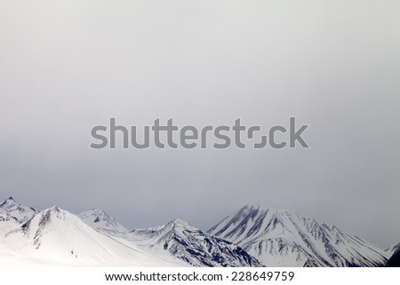 Gray snowy mountains in mist. Caucasus Mountains, Georgia, ski resort Gudauri.
