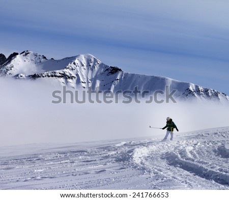 Snowboarder downhill on off-piste slope with newly fallen snow. Ski resort Gudauri. Caucasus Mountains, Georgia.