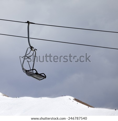 Chair lift and off-piste slope at gray windy day. Caucasus Mountains, Georgia, ski resort Gudauri.
