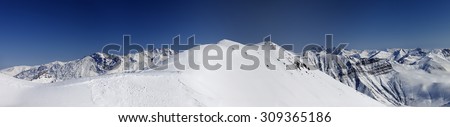 Panorama of snowy mountains at sun day. Caucasus Mountains, Georgia, view from ski resort Gudauri.