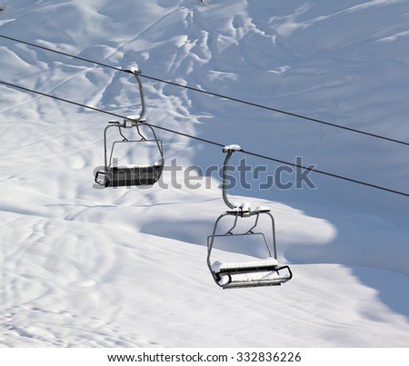 Two chair-lift with snowdrift and off-piste slope in sun morning. Caucasus Mountains. Georgia, ski resort Gudauri.