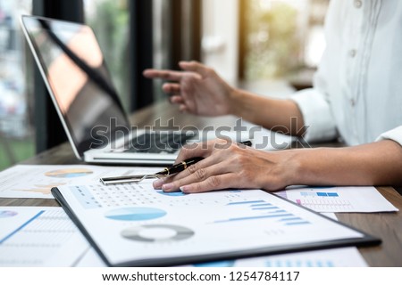 Business woman accountant working audit and calculating expense financial annual financial report balance sheet statement, doing finance making notes on paper checking document.