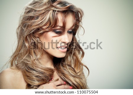 Young brunette lady with a beautiful hair on gray background
