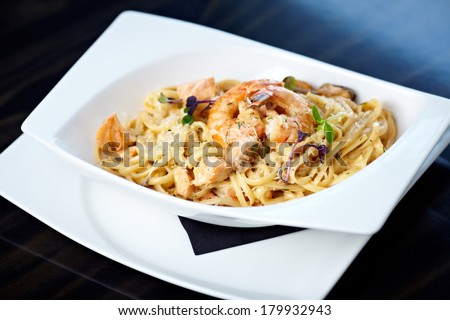 Creamy seafood pasta with salmon, shrimp, mussels and Grana Padano cheese
