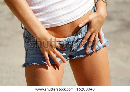 stock photo Torso of sexy tanned girl in jeans shorts