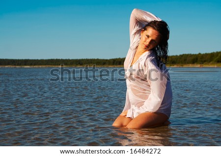 Wet men\'s shirt outlines the naked body of young sexy female model