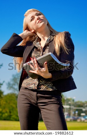 Dreamy businesswoman holding writing-book