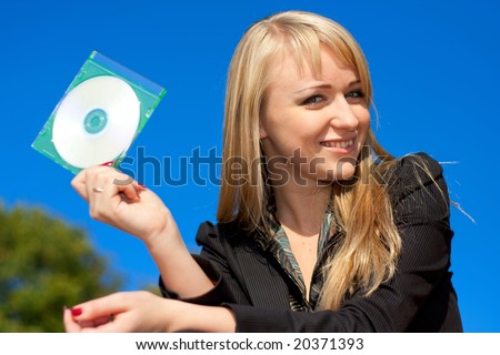 Blond businesswoman holding CD in green cover