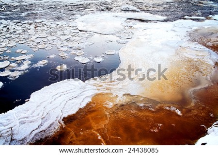 Frozen river with pieces of ice floating in water