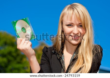 Blond businesswoman holding CD in green cover