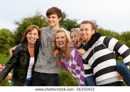 Five friends laughing and having fun in park