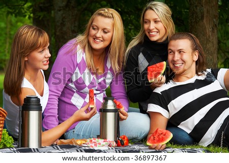 Friends on picnic enjoying fresh watermelon